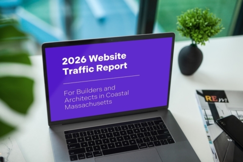 Laptop on a white desk shows a purple slide: '2026 Website Traffic Report' for builders and architects in coastal Massachusetts; a small plant sits nearby.