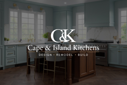 Elegant modern kitchen with seafoam cabinets, marble backsplash, and central wooden island; logo text “Cape & Island Kitchens” overlays the scene.